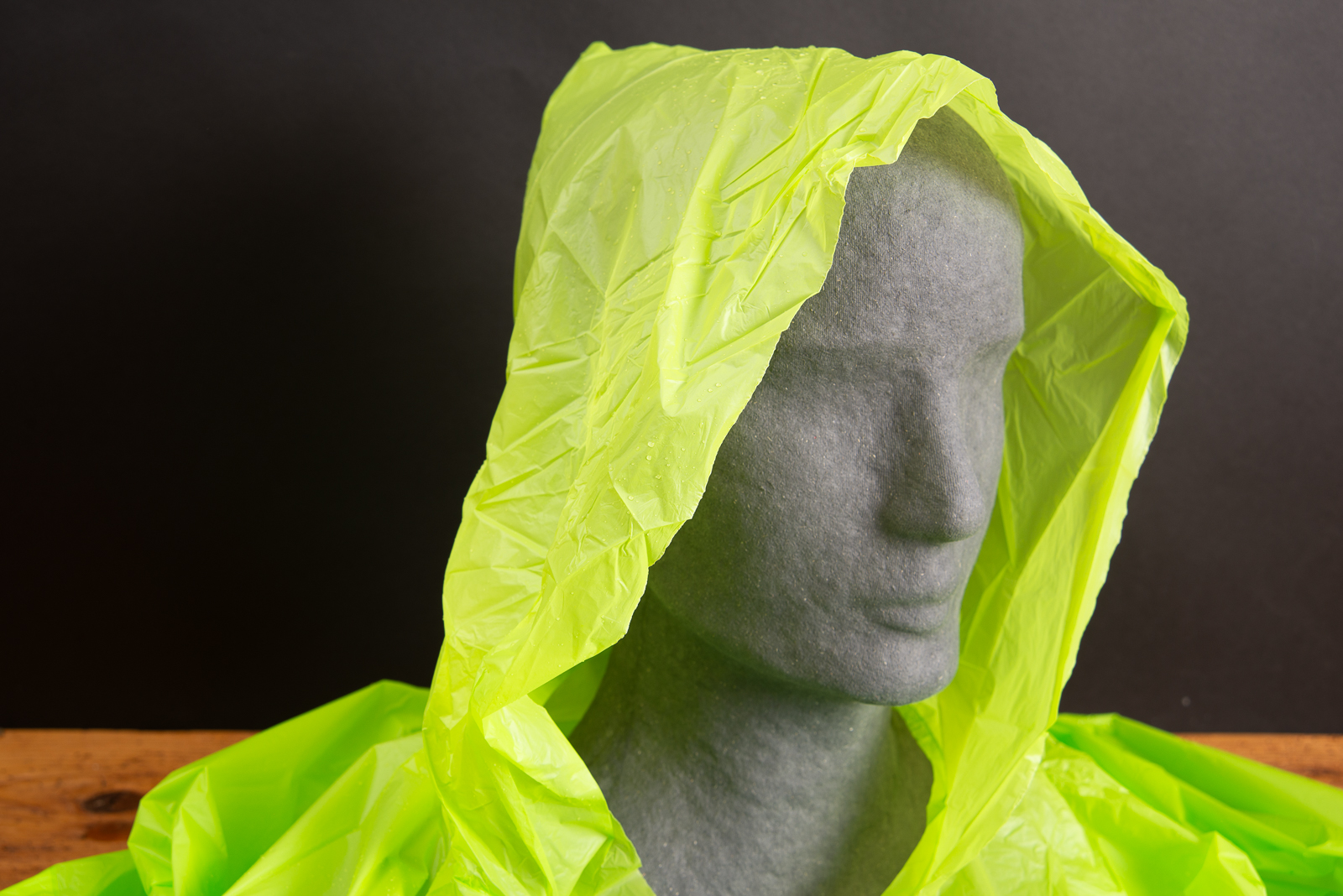 Detailansicht eines gr&uuml;nen Regenponchos mit Kapuze aus biologisch abbaubarer Maisst&auml;rke &ndash; nachhaltiger Regenponcho mit Logo als umweltfreundliches Werbegeschenk f&uuml;r Events und Festivals von werbemax