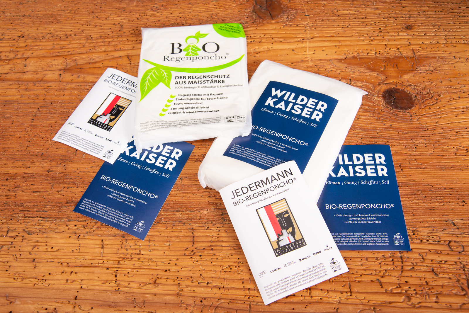 Individuell gestaltete Verpackungen biologisch abbaubarer Regenponchos aus Maisst&auml;rke &ndash; nachhaltige Regencapes mit Logo als umweltfreundliche Werbegeschenke f&uuml;r Events, Festivals und Tourismus von werbemax.
