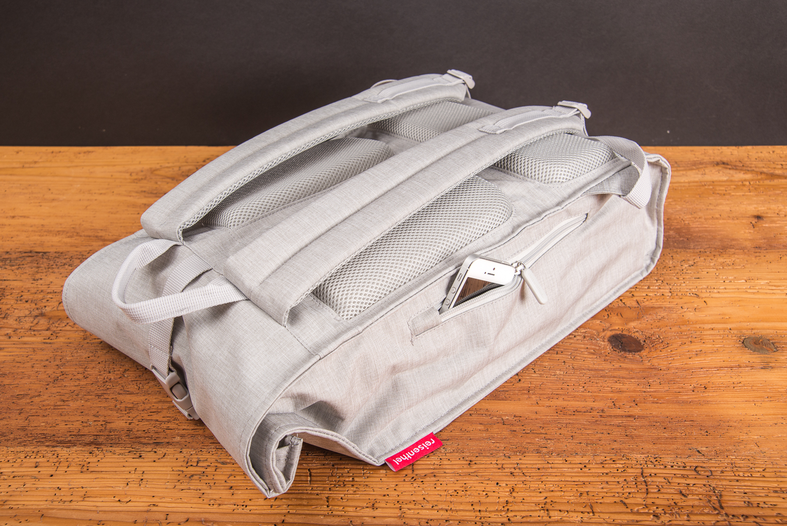 R&uuml;ckseite des Reisenthel Rolltop Rucksacks in hellem Grau mit gepolsterten Tr&auml;gern und Rei&szlig;verschlussfach &ndash; moderner, funktionaler Rucksack als nachhaltiges Mitarbeitergeschenk oder Werbeartikel f&uuml;r unterwegs.