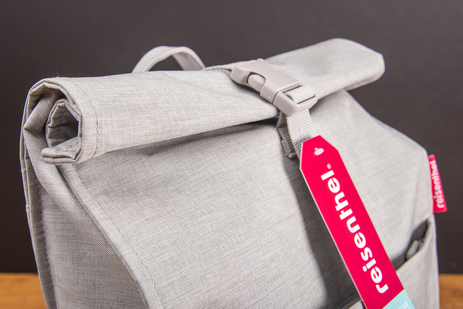 Detailaufnahme des Reisenthel Urban Rolltop Rucksacks in Grau mit Rollverschluss und Logoanh&auml;nger &ndash; nachhaltiger Design-Rucksack aus recyceltem Material als moderner Werbeartikel oder Mitarbeitergeschenk.