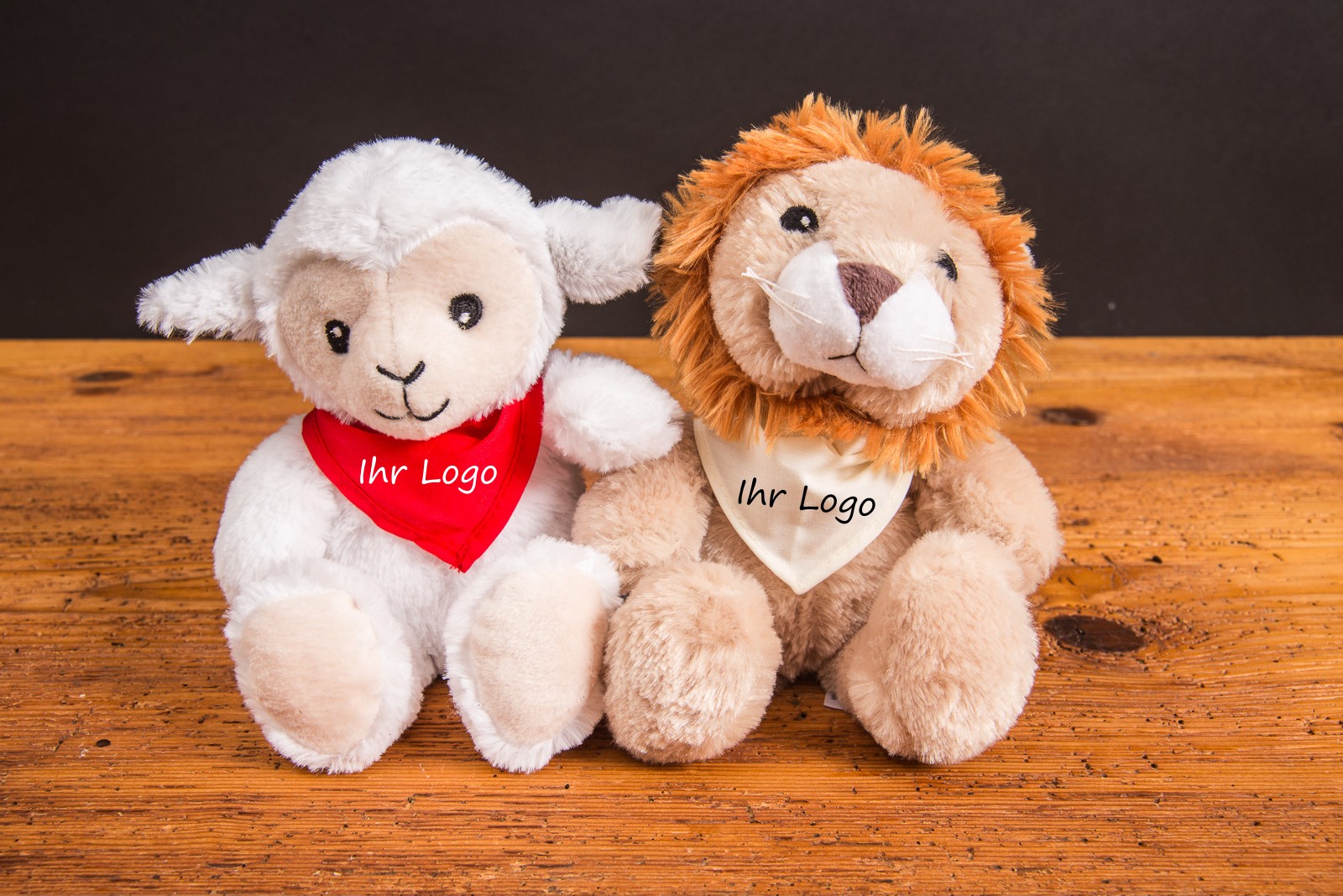 W&auml;rmekuscheltier mit Logo Habibi Plush Lamm und L&ouml;we &ndash; W&auml;rmekissen Werbegeschenk mit bedrucktem Halstuch und nat&uuml;rlicher Hirsef&uuml;llung