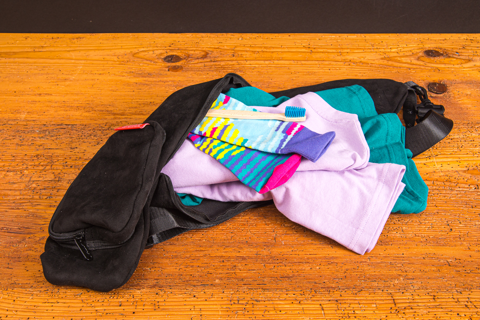 Travel Pillow Reisekissen mit Kleidung bef&uuml;llt &ndash; platzsparendes Nackenkissen aus recyceltem Wildleder als Werbegeschenk.