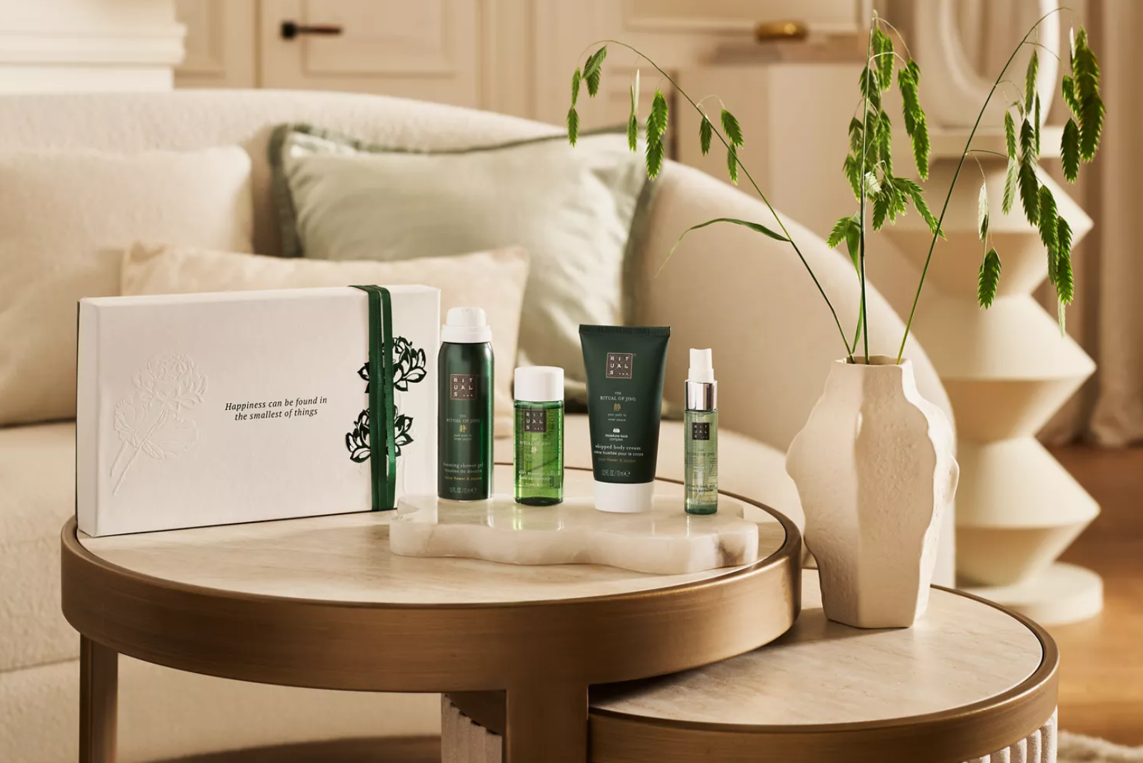 Rituals Jing Geschenkset mit Pflegeprodukten und eleganter Geschenkbox auf modernem Wohnzimmertisch &ndash; ideales Mitarbeitergeschenk.