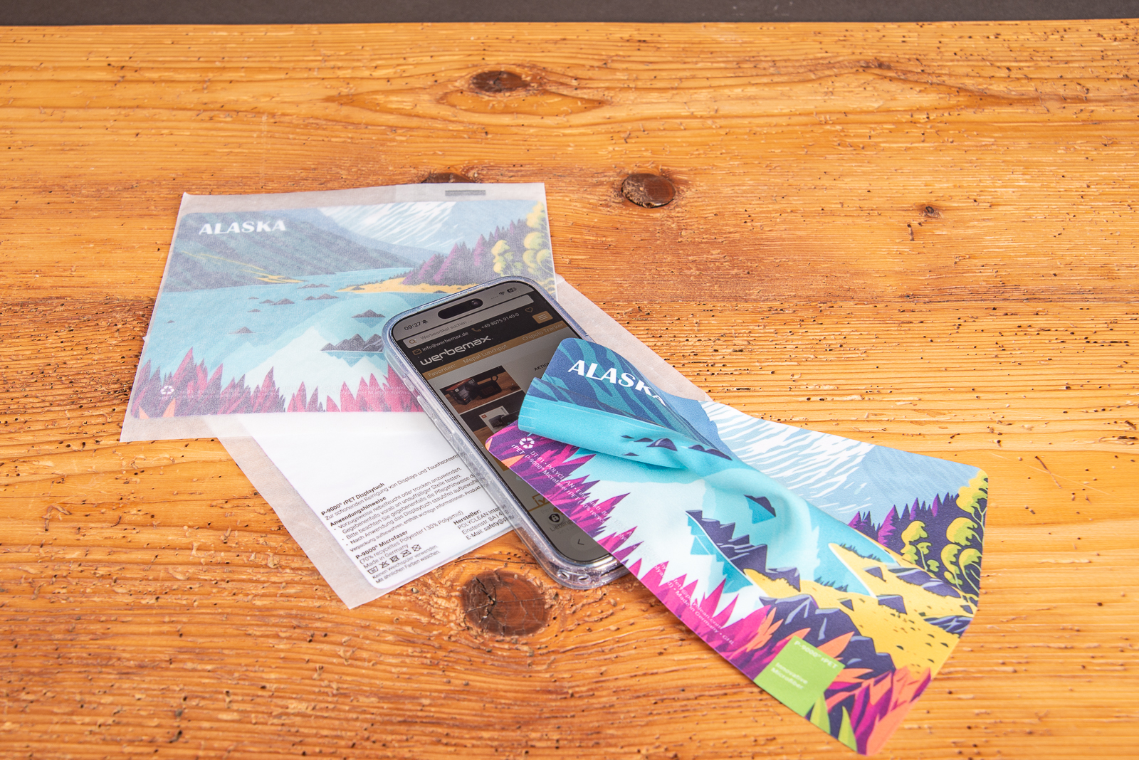 Microfasertuch mit Logo reinigt Touchscreens streifenfrei auf Smartphone und Einlegekarte als nachhaltiger Werbeartikel.