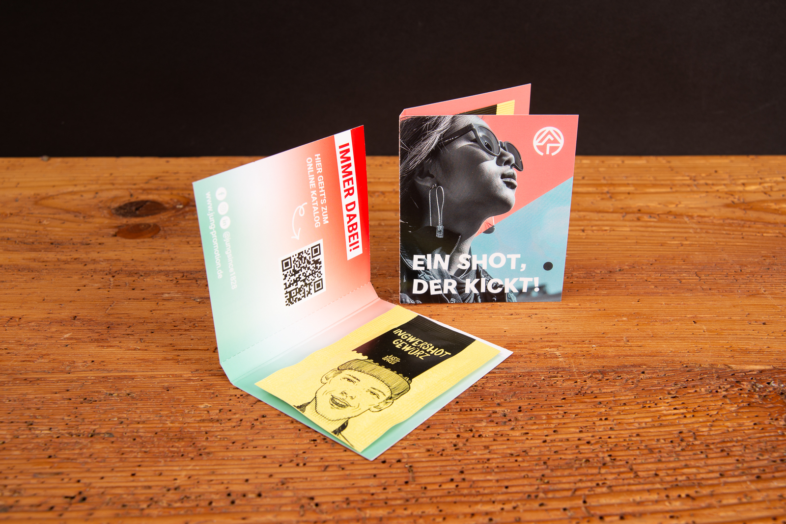 Werbekarte Midi Just Spices mit Avocado Topping als individuell bedruckter Werbeartikel; ge&ouml;ffnete Gew&uuml;rzkarten als moderne Messe-Giveaways auf Holztisch, ideal zum Werbeartikel bedrucken.