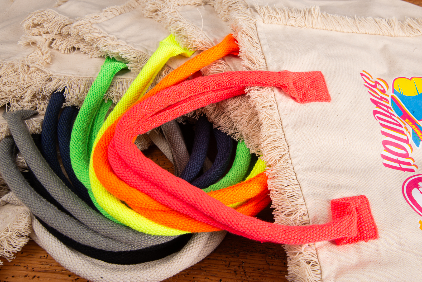 Strandtasche Lola als Werbegeschenk &ndash; Detailaufnahme der neonfarbenen Kordelgriffe an Fairtrade-Baumwolltasche