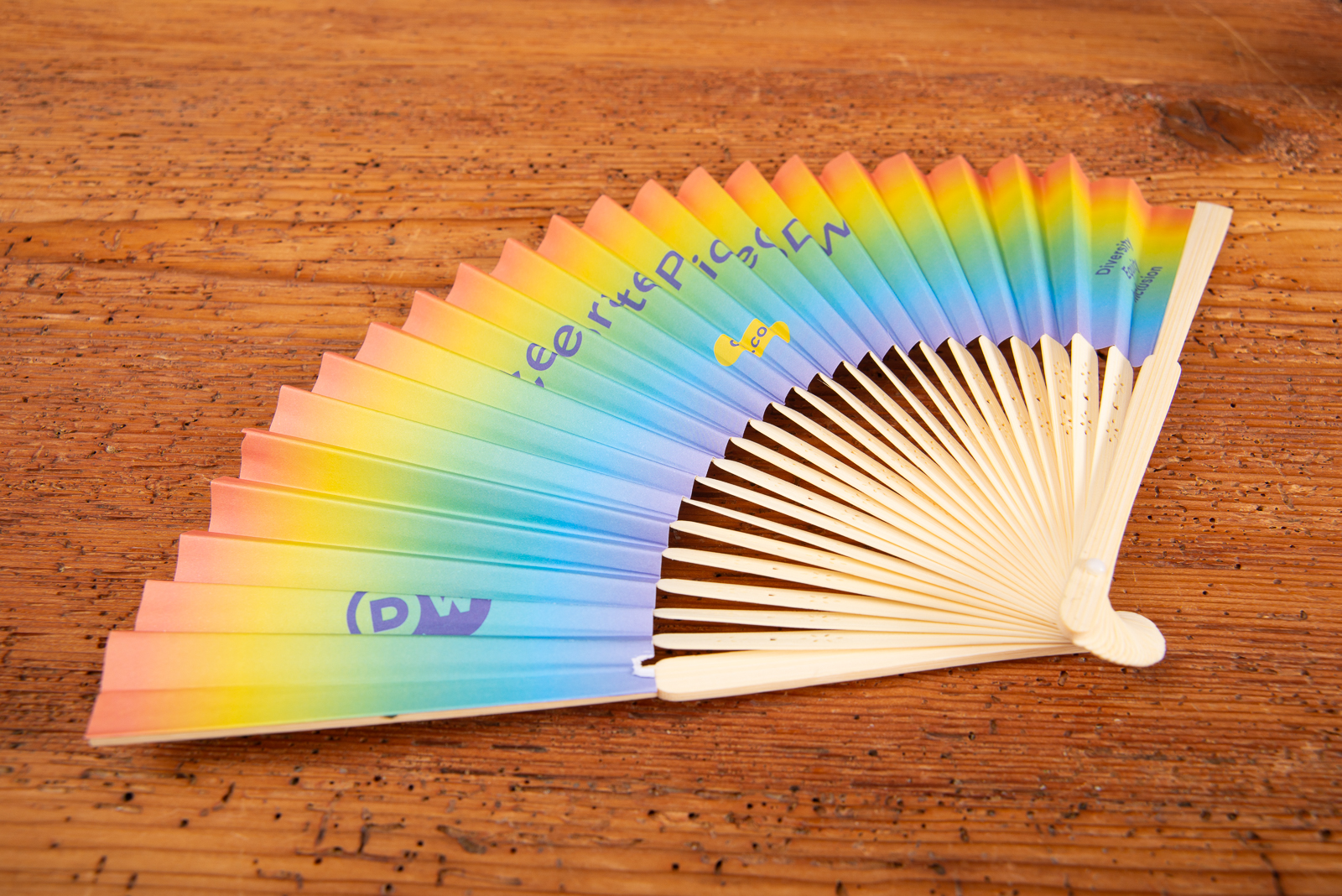 Regenbogen F&auml;cher mit Logo bedrucken als kreativer Werbeartikel f&uuml;r Festival und Promotion