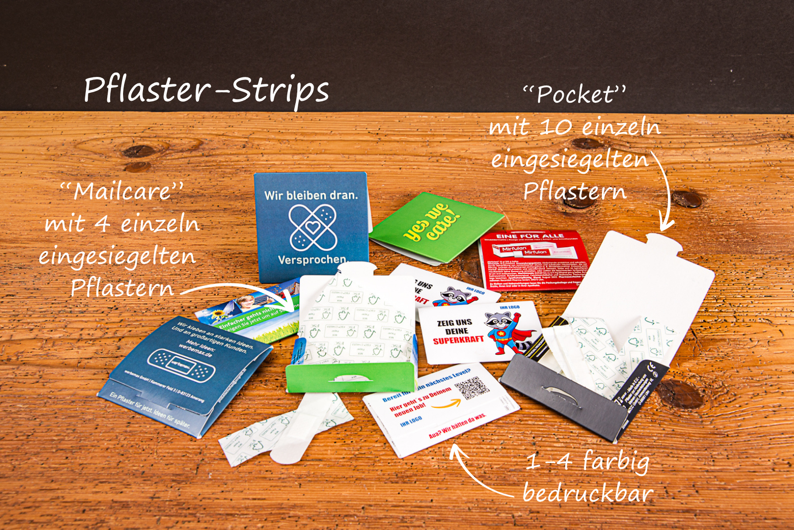Individuell bedruckte Pflasterm&auml;ppchen in den Varianten Pocket und Mailcare mit ECO-Pflasterstrips auf einem Holztisch pr&auml;sentiert.