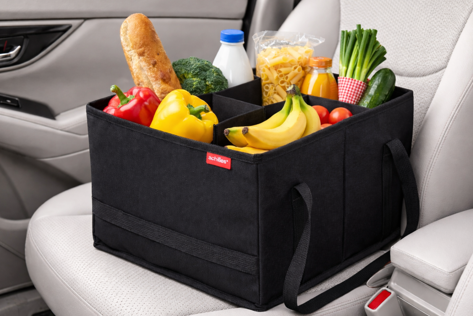 Schwarzer Einkaufs-Organizer auf einem Autositz gef&uuml;llt mit Lebensmitteln wie Obst und Gem&uuml;se &ndash; der ideale Kofferraum Organizer und Werbeartikel f&uuml;r sicheren Transport.