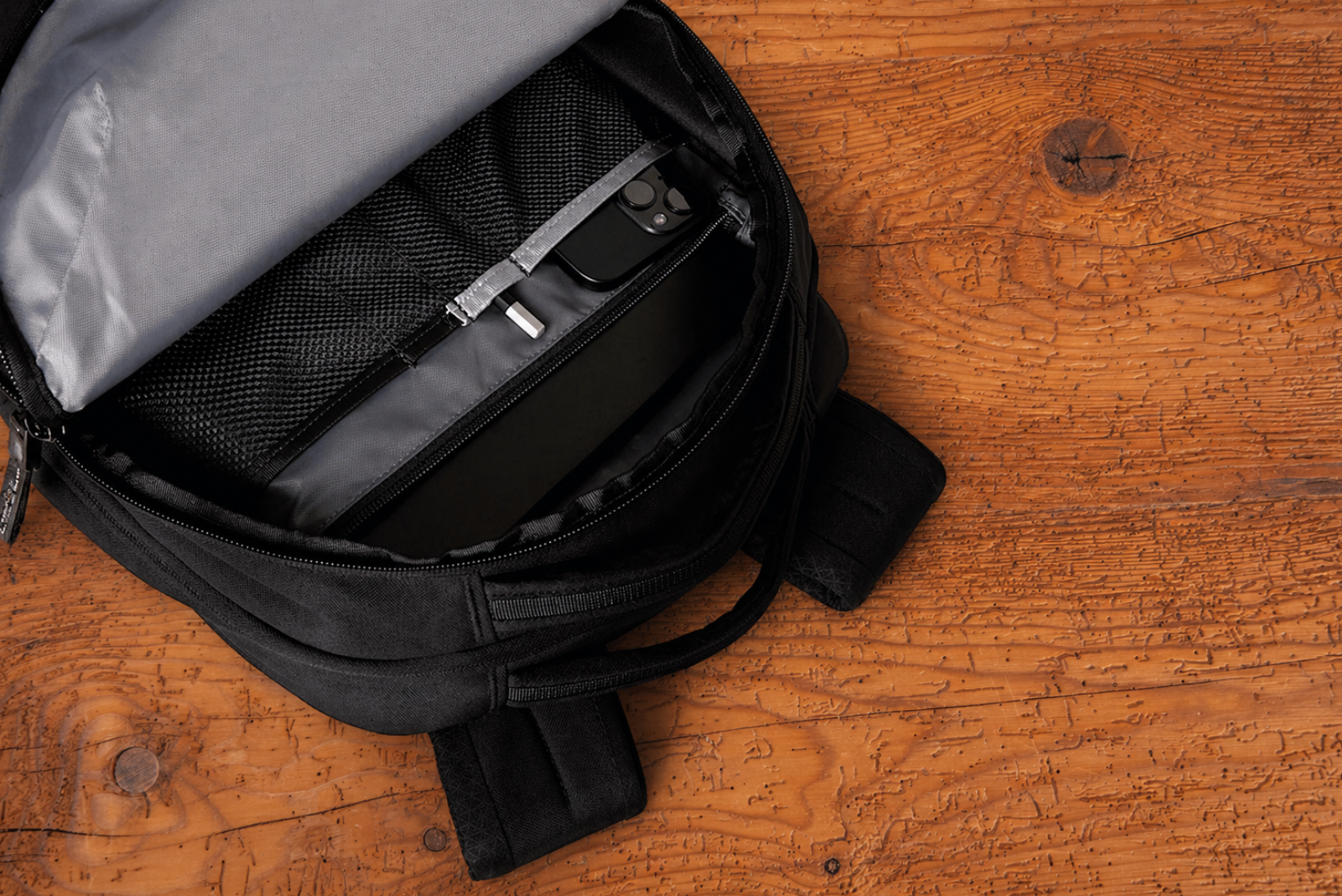 Innenansicht des The North Face VAULT Rucksacks mit Laptopfach und Organisationsf&auml;chern als Werbeartikel mit Logo auf Holzoberfl&auml;che.