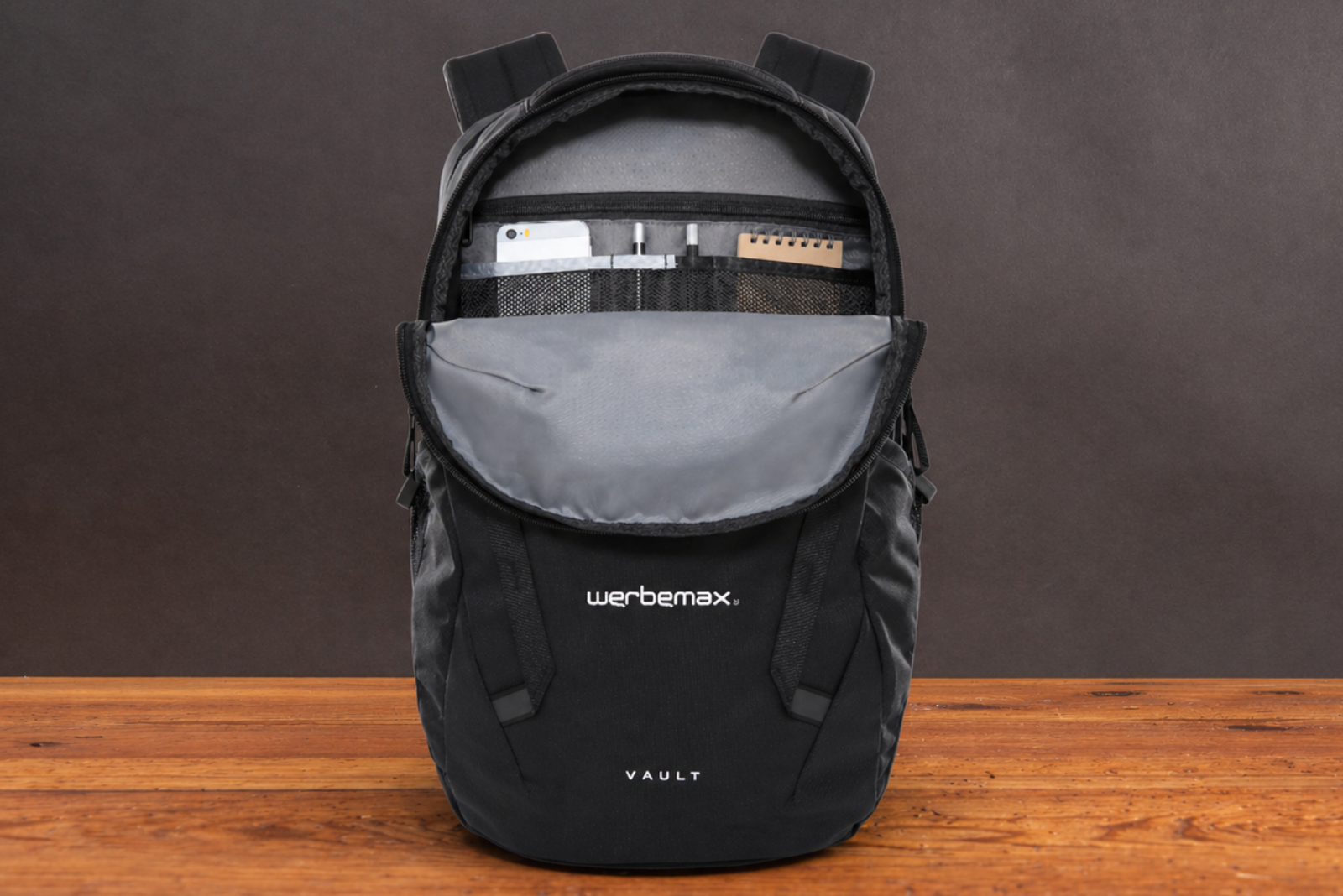 The North Face VAULT Rucksack mit Logo als hochwertiger Werbeartikel f&uuml;r Mitarbeiter und Kunden auf Holztisch.
