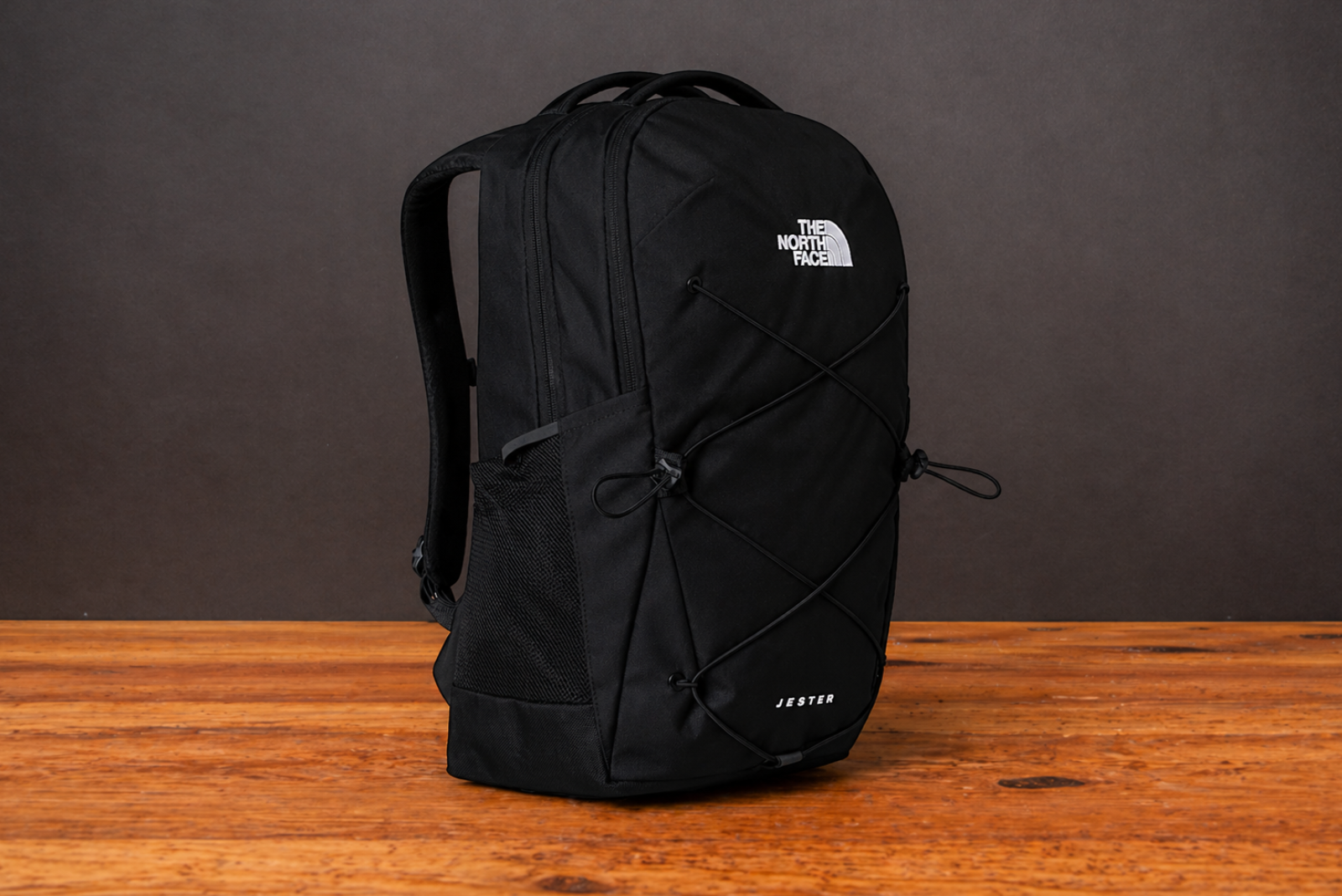 The North Face Jester Rucksack in Schwarz als hochwertiger Werbeartikel mit Logo auf Holztisch inszeniert.