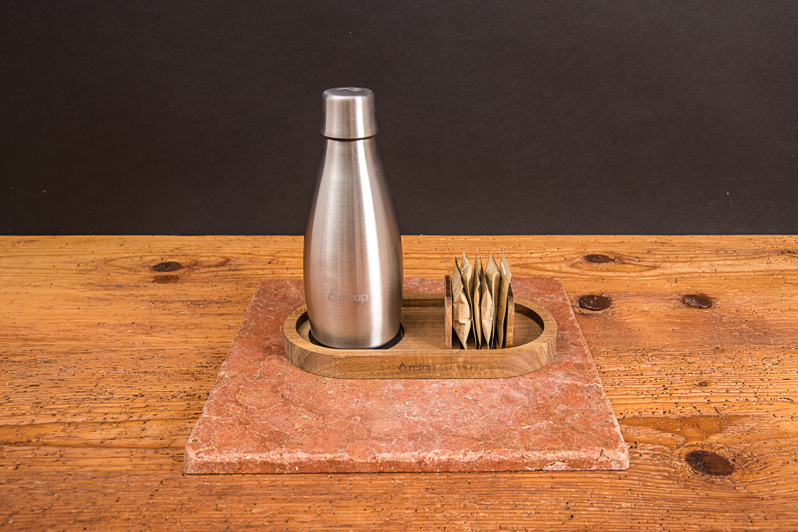 Retap Wooden Tray aus Eichenholz mit einer 0,5l Edelstahlflasche und Flavours als hochwertiges Geschenk zur Mitarbeiterbindung auf einem Holzschreibtisch von werbemax.