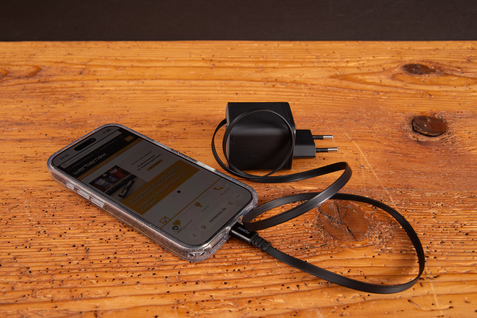 SUPPLY 65 C GaN Ladestecker 65W mit EU-Netzstecker und ausgezogenem USB-C-Kabel neben einem Smartphone auf Holzfl&auml;che