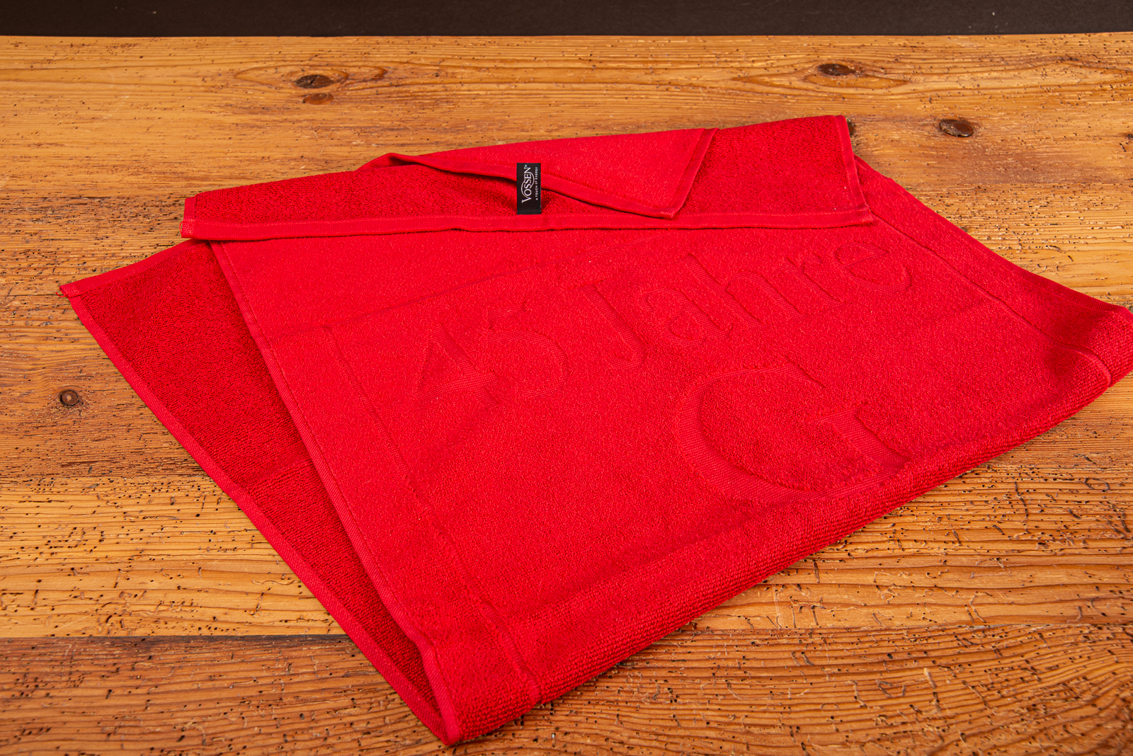 Individuell gestaltetes rotes Handtuch mit eingewebtem Logo und schwarzem Vossen Label.