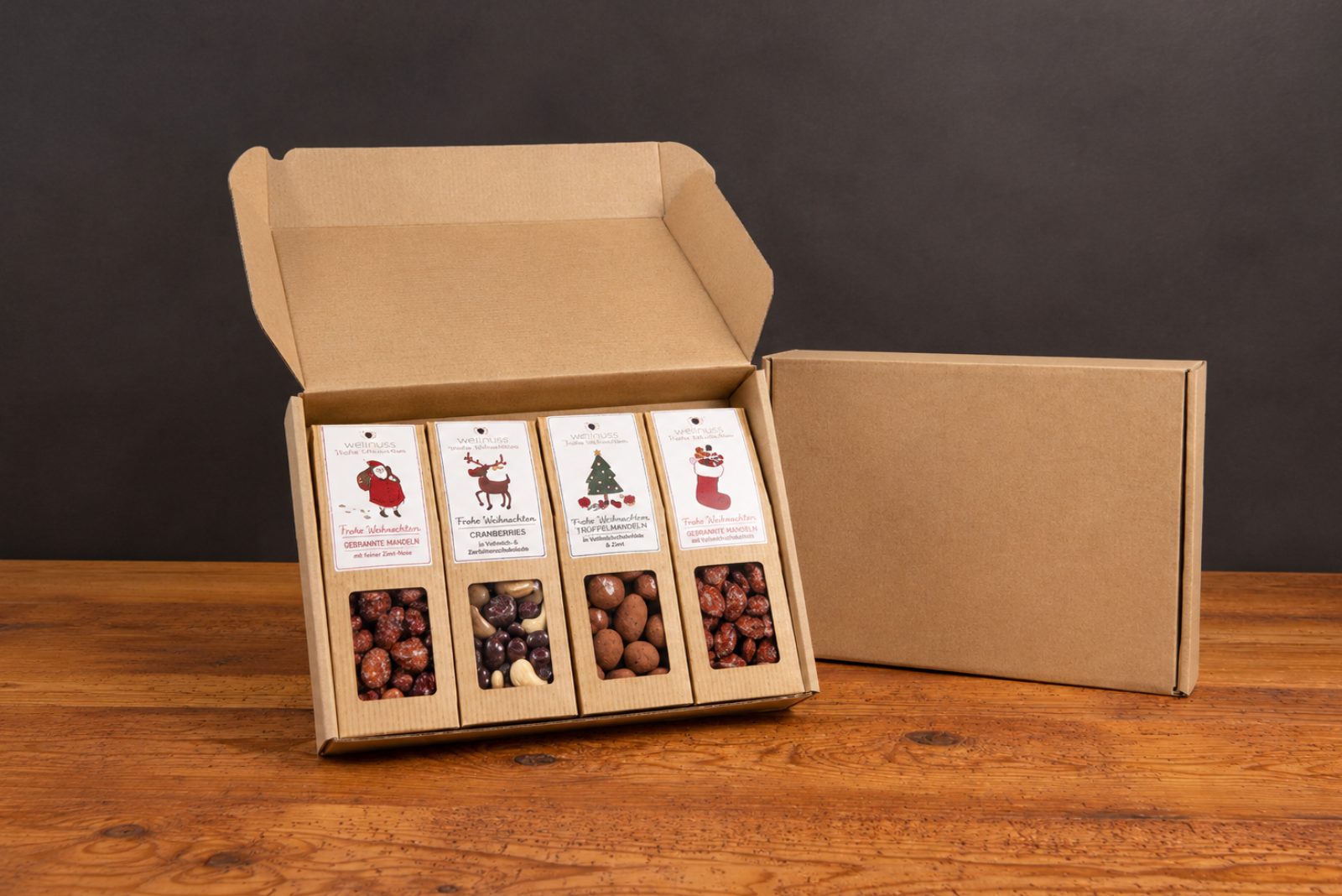 wellnuss Faltschachteln mit weihnachtlichen Motiven in der Versandbox als Mitarbeitergeschenk.
