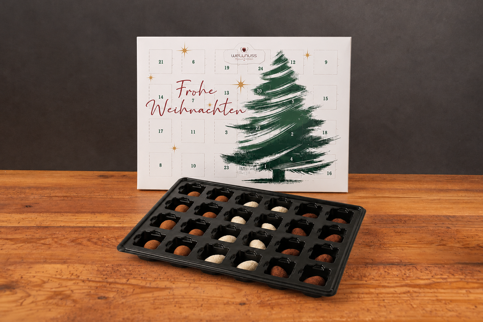 Premium Adventskalender mit Weihnachtsbaum-Motiv auf rustikaler Holzplatte vor schwarzem Hintergrund &ndash; hochwertige Geschenkidee f&uuml;r Weihnachten.