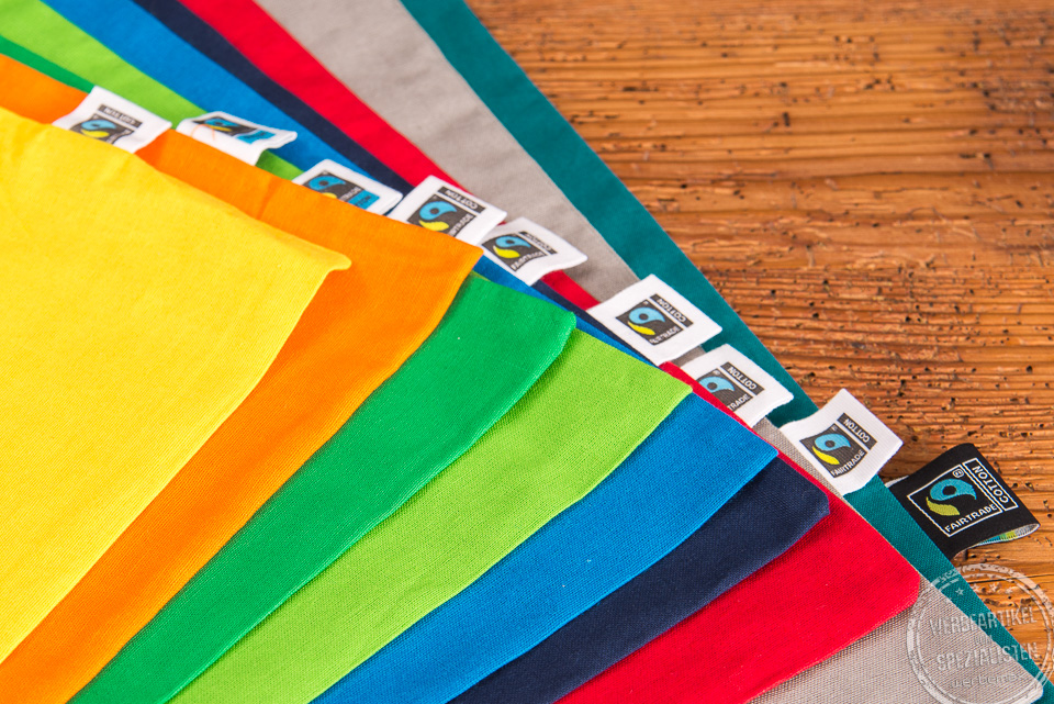 Nahaufnahme der Messetasche Elsa in den verschiedenen Farben mit Fairtradelabel