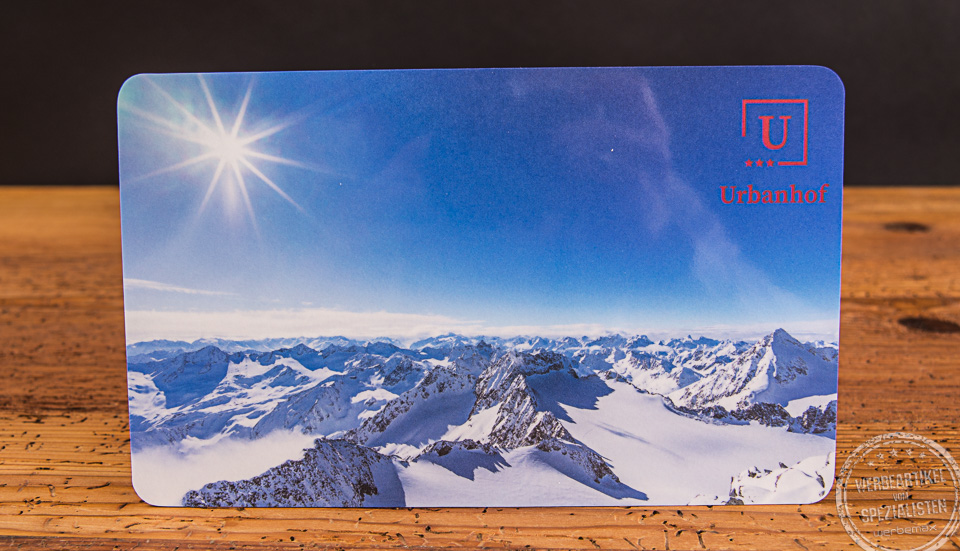 Brotzeitbrett mit winterlichem Bergmotiv und Logo Urbahnhof S&ouml;lden als Werbegeschenk.