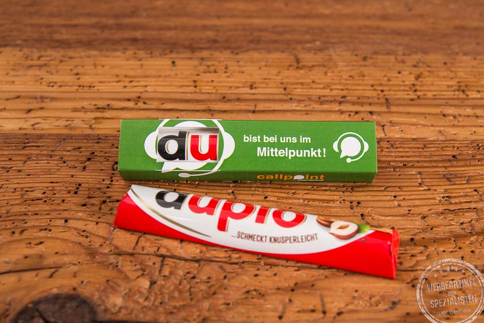 Duplo Schokoriegel im individuell bedruckten Werbeschuber mit Osterdesign, Aufschrift &bdquo;Du bist wichtig f&uuml;rs Team&ldquo;, s&uuml;&szlig;em Hasenmotiv und bunten Ostereiern &ndash; kreativer Werbeartikel zu Ostern f&uuml;r Mitarbeitermotivation und Kundenbindung.