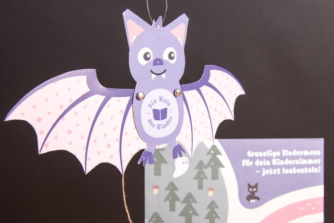 Gebastelte lila Fledermaus aus dem Halloween-Bastelset für Kinder, umgesetzt als kreativer Werbeartikel für Hugendubel.
