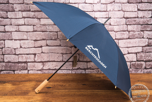blauer Stockschirm mit weißem Logodruck auf einem Keil