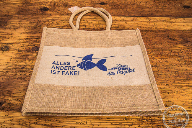 Jutetasche mit kurzen Henkeln. Blauer Aufdruck der Firma Pössl