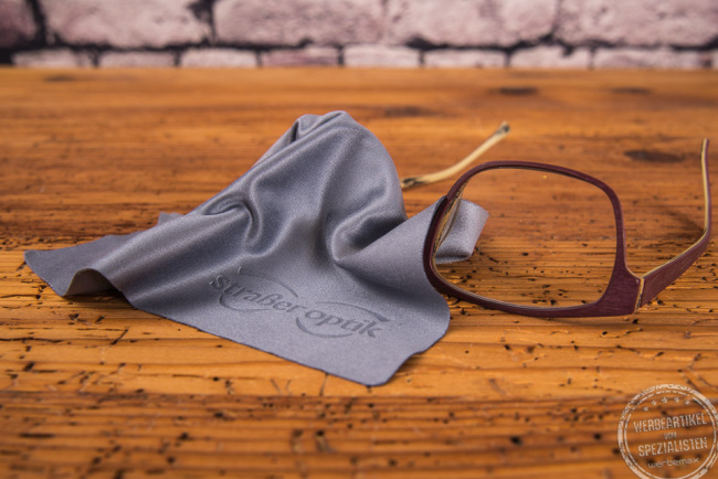 Brillenputztuch in Grau auf einer Brille