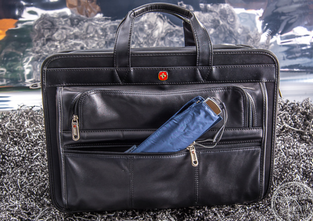 Kompakter Hand&ouml;ffner Regenschirm von Samsonite in Dunkelblau in einer Aktentaschen verstaut. Der kleine Reiseschirm passt in jede Tasche.