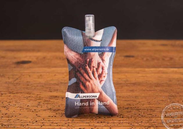 HFX Displayreiniger mit fotorealistischem Druck auf der Microfaseroberfl&auml;che,  mehrere H&auml;nde &uuml;bereinander die Zusammenhalt und Teamspirit verk&ouml;rpern