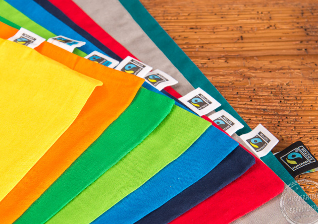 Nahaufnahme der Messetasche Elsa in den verschiedenen Farben mit Fairtradelabel
