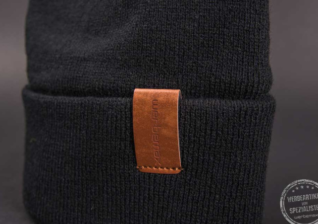 Schwarze Beanie M&uuml;tze mit Leder Logo als Werbeartikel 