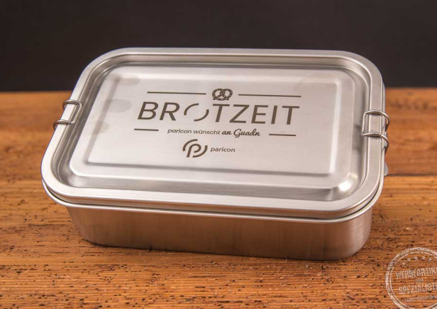 Nachhaltige Brotdose STEEL mit Logogravur als Kundengeschenk mit Will-Haben-Faktor auf Holztisch.