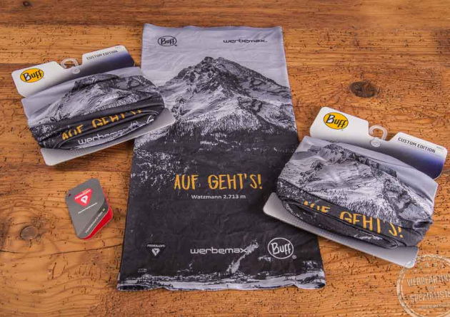 Buff Thermonet allover bedrucken als Werbegeschenk im Eigendesign liegt auf Holztischplatte.