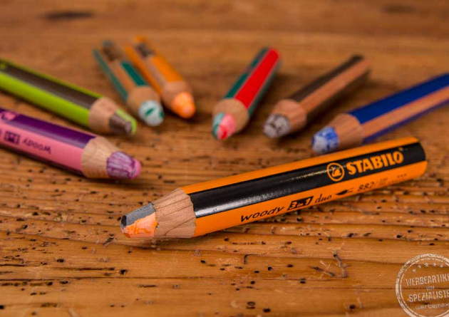 Stabilo Woody 3in1 in unterschiedlichen Farben als Merchendise auf Holztisch.