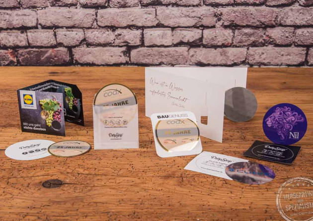 Drop Stop Weinausgie&szlig;er diverse Umsetzungsbeispiel mit Fotodruck und Verpackungsgestaltung auf Holztisch. 