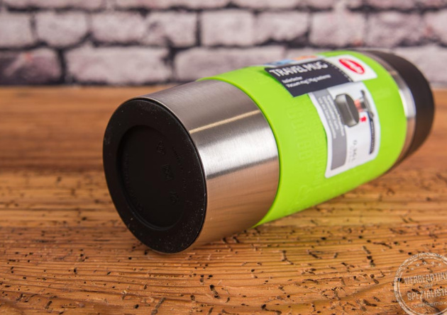 emsa travel mug kaffeebecher in gr&uuml;n liegend auf Holztisch mit Ansicht rutschfester Boden.