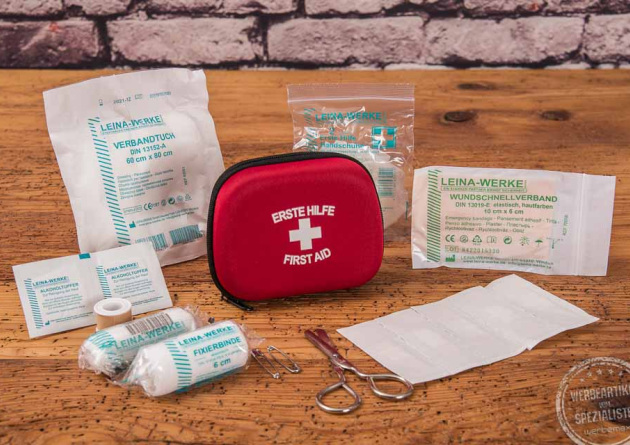 Rotes Erste Hilfe Set als Werbeartikel mit Klebeband, Schere, Fixierbinde, Wundschnellverband und Alkoholtupfer 