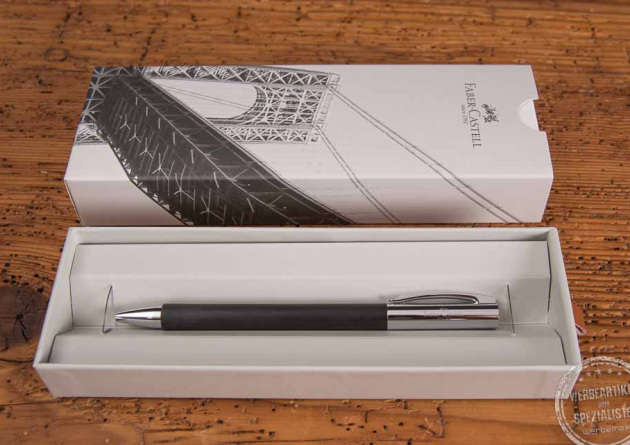 Faber-Castell Ambition Kugelschreiber als stilvolles Inventiv in Verpackung auf Holztisch.
