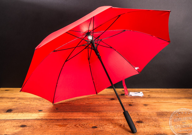 Fare AC Midsize Stockschirm Skylight in rot und mit schwarzem Griff auf Holzplatte als Werbeartikel.  