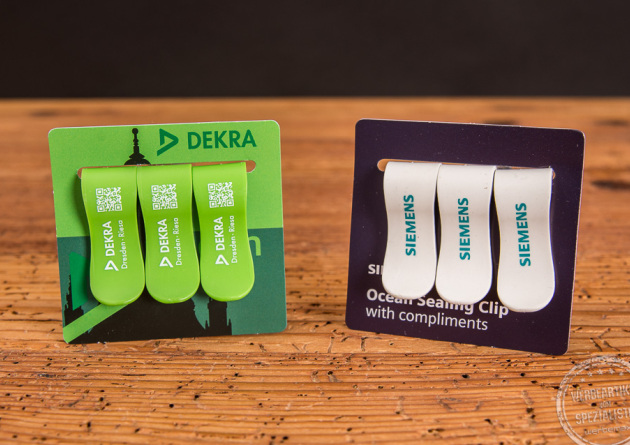 Zwei 3er Sets der Ocean Clamps - nachhaltige Tütenclips aus recyceltem Plastik in Grün und Dekra-Logo sowie weiß und Siemenslogo