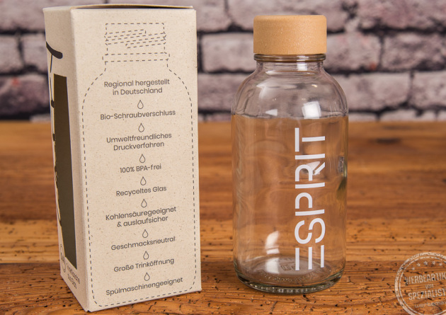 Carry-Bottle Trinkflasche mit Logo als Event-Zugabe auf Holztisch.