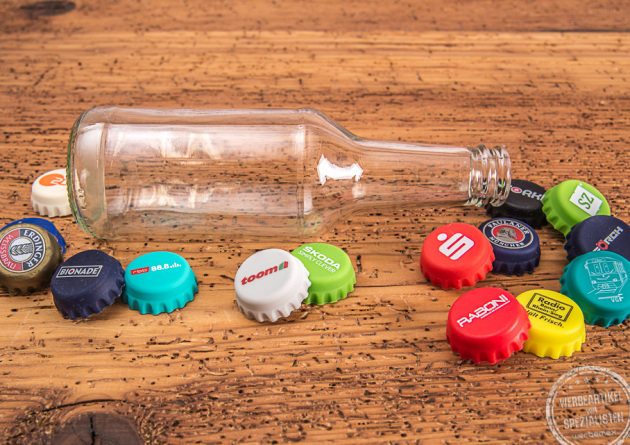 Leere Glasflasche mit verschiedenen Kronkorken aus Silikon