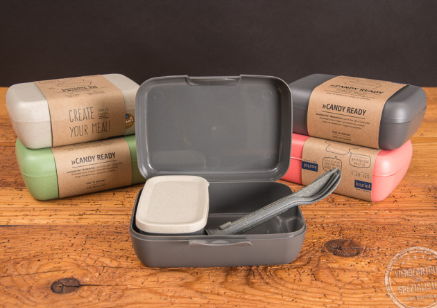 F&uuml;nf koziol Candy Ready Set Lunchboxen in den Farben wei&szlig;, gr&uuml;n, grau und rot, wobei eine graue Candy Ready Lunchbox ge&ouml;ffnet ist. 