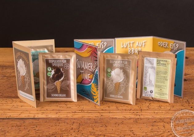 Mailingf&auml;higer Werbeartikel wellnuss Eispulver im Portionsbeutel in der Werbekarte auf Holztisch.