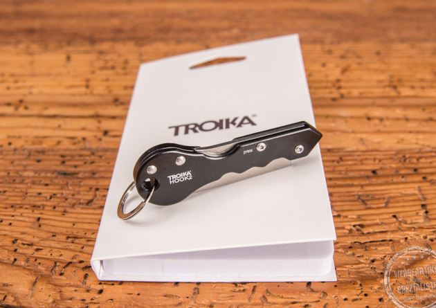 Paketmesser Troika Hook2 liegend auf Verpackung als Werbeartikel. 