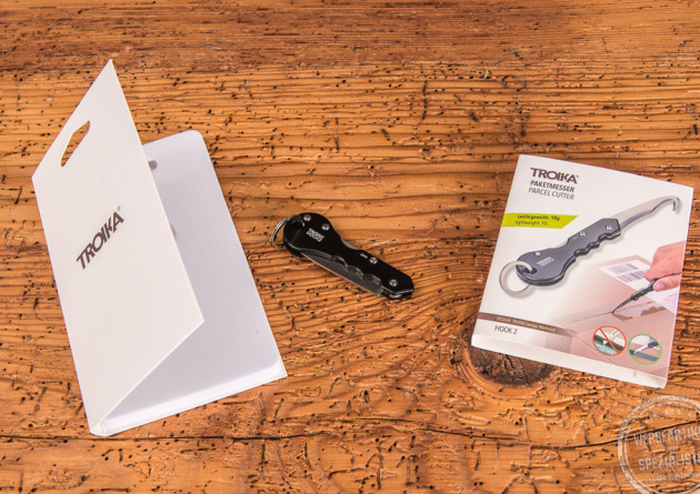 Troika Paketmesser Hook2 geschlossen liegend zwischen den Verpackungen. 
