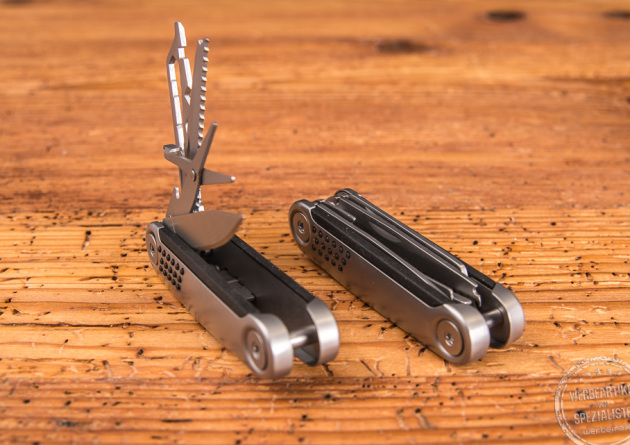 Zwei Taschenmesser als Werbegeschenk liegend auf Holzfläche, ein Taschenmesser ist geöffnet.