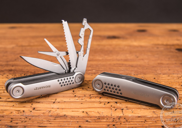 Zwei Taschenmesser Richartz Struktura Knife 15+ als Werbegeschenk auf Holzfl&auml;che liegend, eines davon ge&ouml;ffnet. 