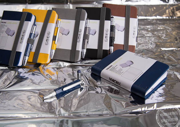 Schreibblock und Stift f&uuml;r unterwegs mit Werbedruck in f&uuml;nfverschiedenen Farben, rot, gelb, schwarz, grau und blau